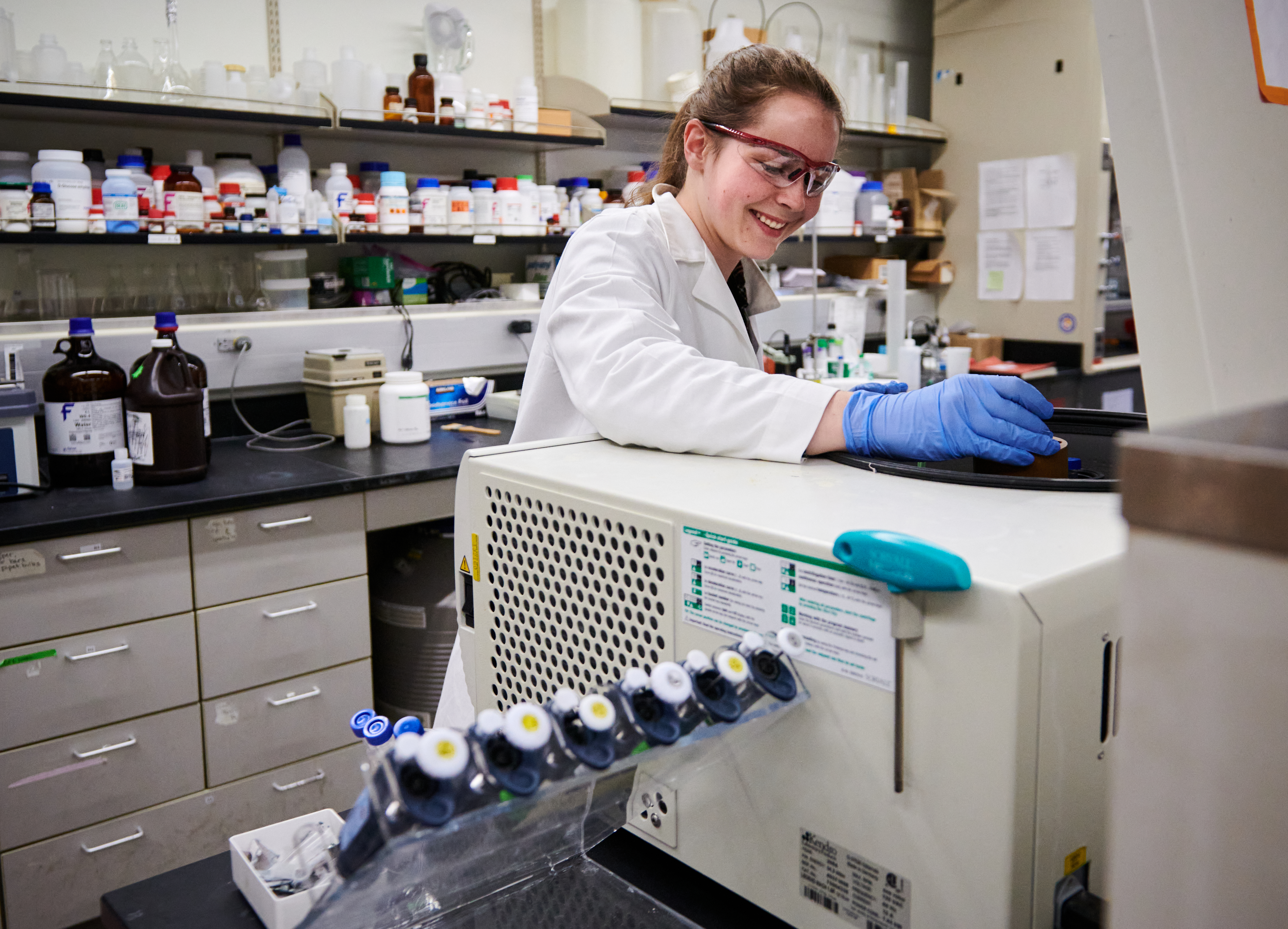 2022 REU student loads protein samples into the centrifuge. 