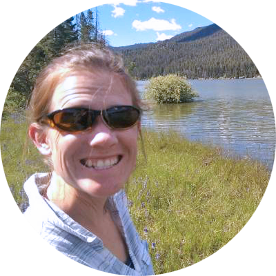 Dr. Ellen Lauchnor smiles at the camera while standing along a riverbank. 