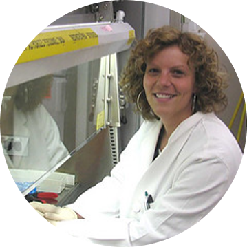 Photo of Dr. Kelly Kirker working in the lab. She is smiling at the camera.