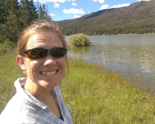 Photo of Ellen Lauchnor smiling at camera with lake in background.
